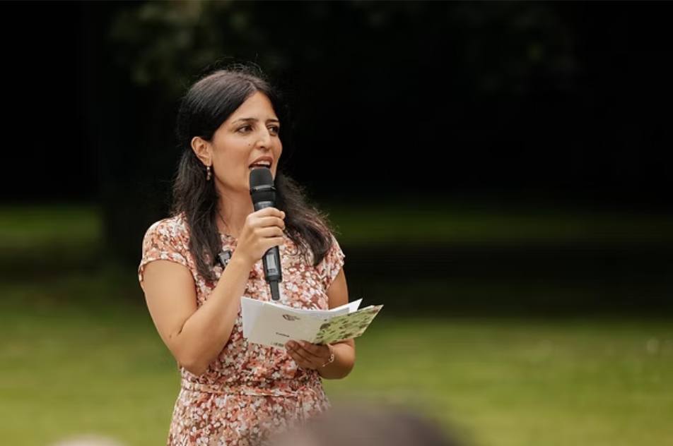 Katty spricht bei einer Gartenhochzeit zu den Gästen